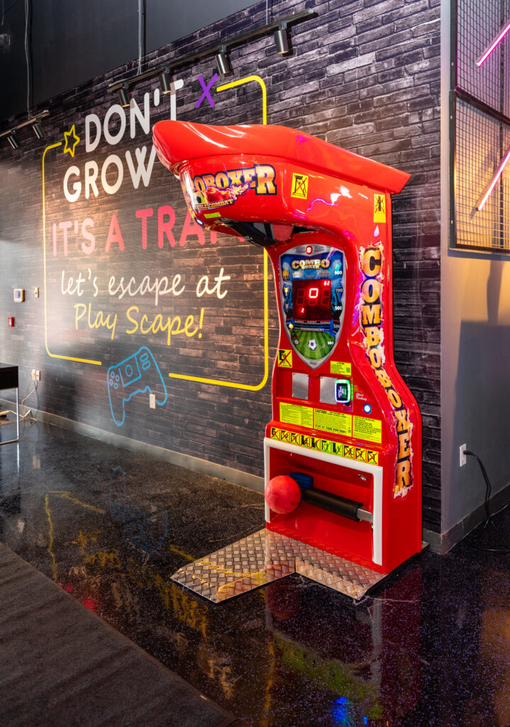 Brightly lit hallway of arcade machines at The Play Scape indoor play area in Scarborough
